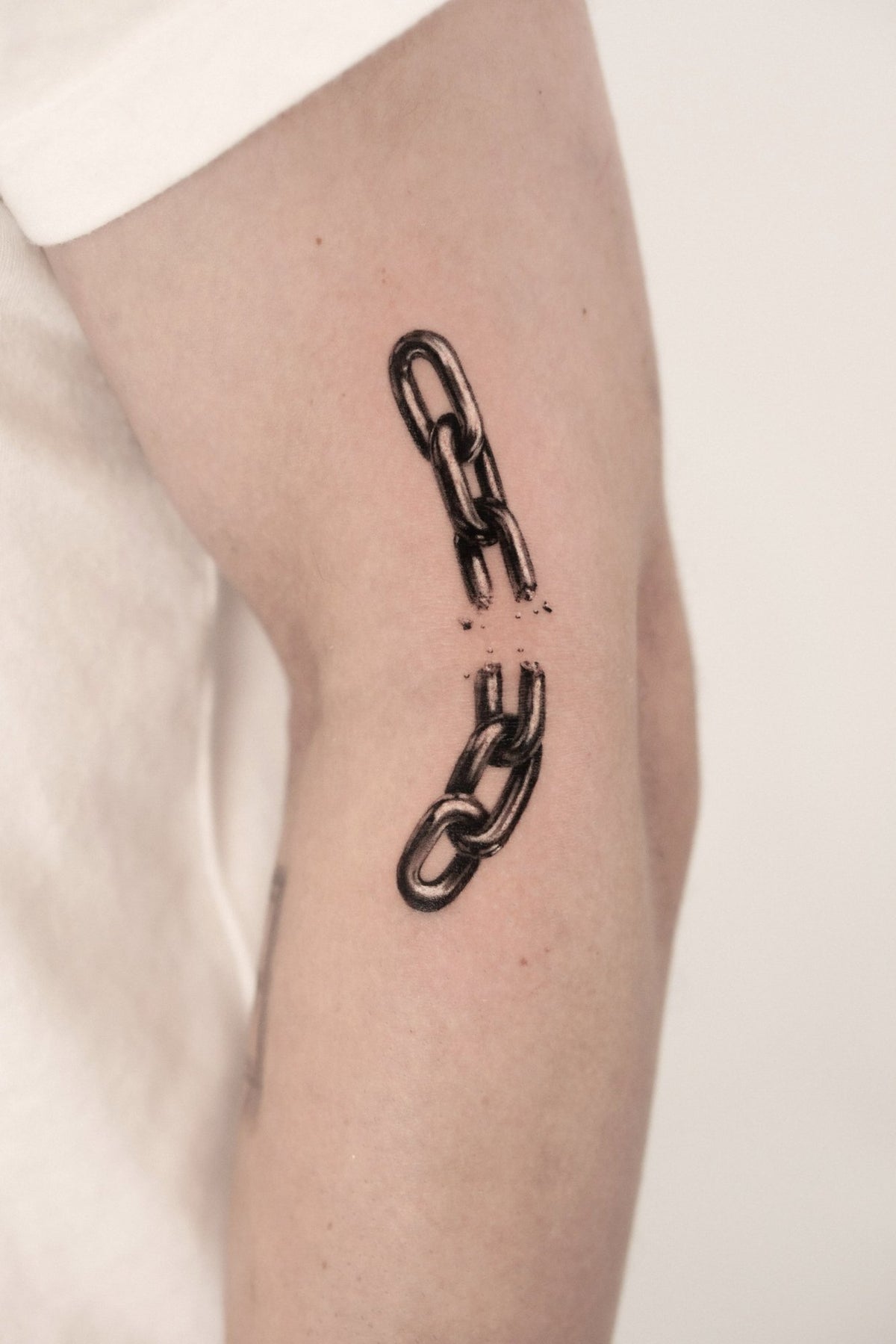 Realism tattoo of a broken chain by Fabio Pillon, The White Whale Tattoo Society, Milano