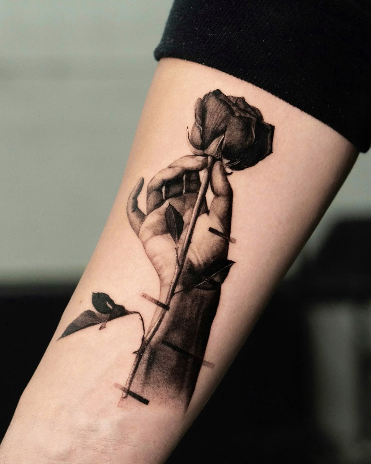 Realism tattoo of a hand holding a rose by Fabio Pillon, The White Whale Tattoo Society, Milano