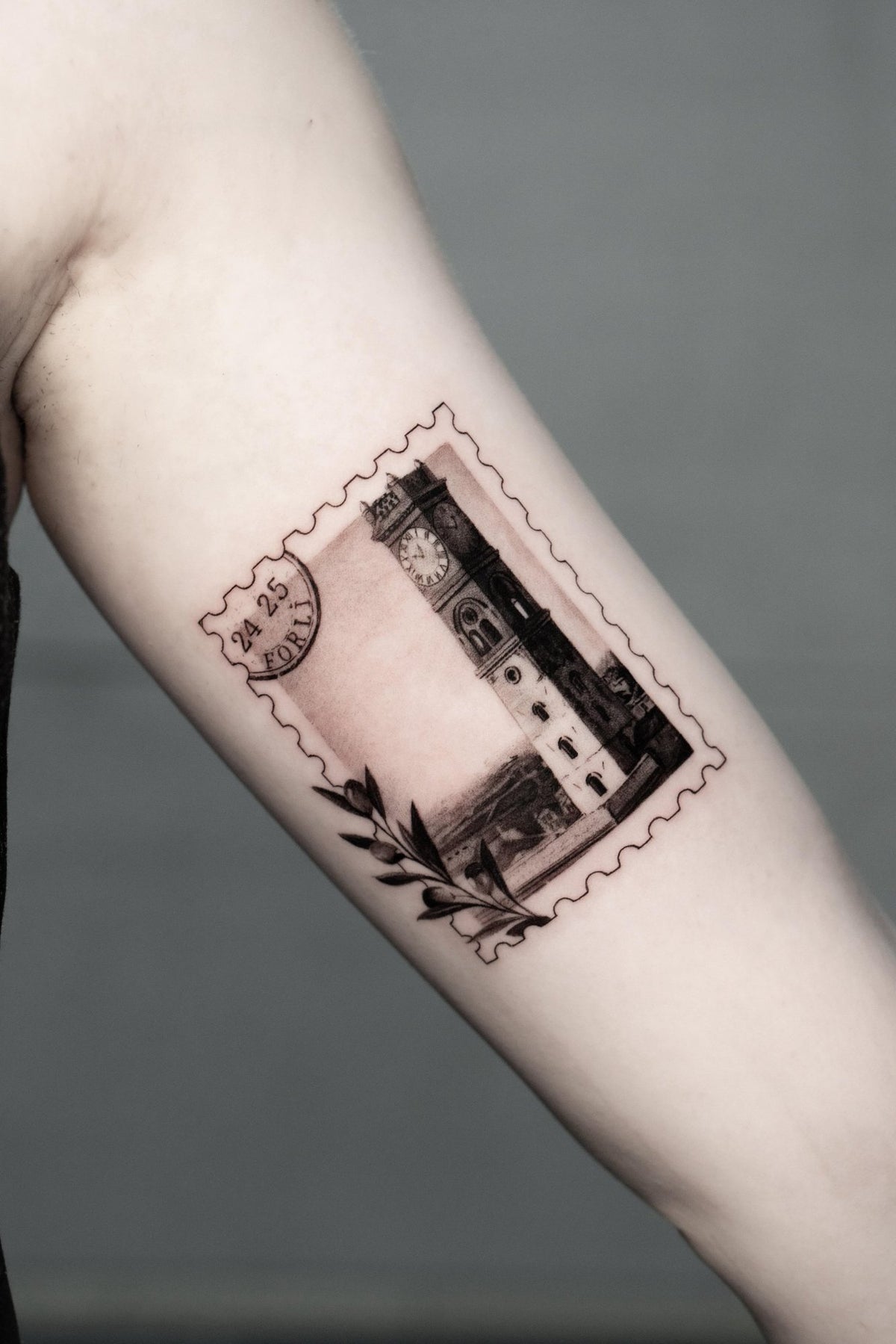 Microrealism stamp tattoo with the Forlì clock tower by Fabio Pillon, The White Whale Tattoo Society, Milano